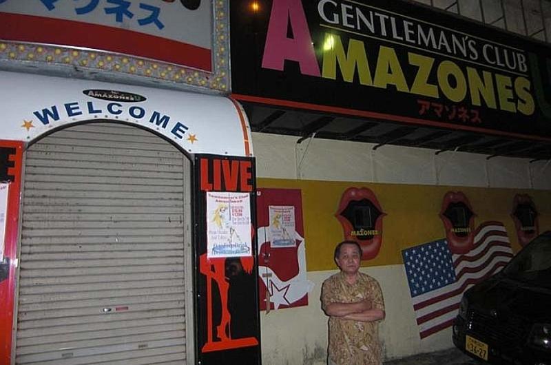 Tsutomu Arakaki, owner of Amazonesu, a club located on Gate 2 Street, outside Kadena Air Base, Okinawa, stands in front of his shuttered bar on Oct. 23, 2012.