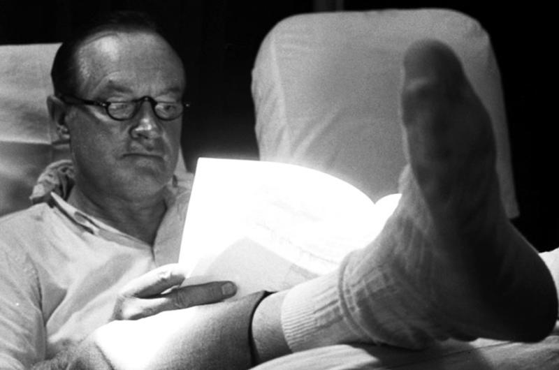 Bob Hope catches up on some paperwork during the flight to the next stop on his 1964 Christmas tour of Vietnam.