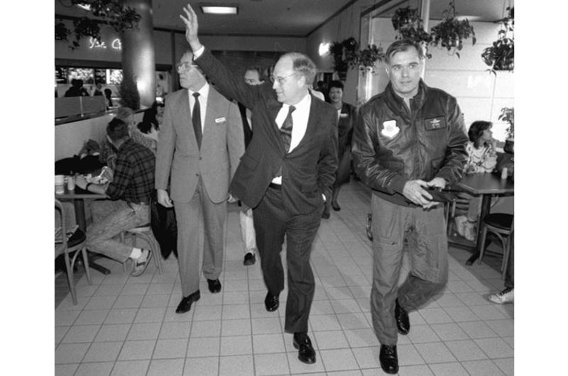 Secretary of Defense Dick Cheney waves to customers as he walks through the food court at Misawa Air Base, Japan, in 1990.