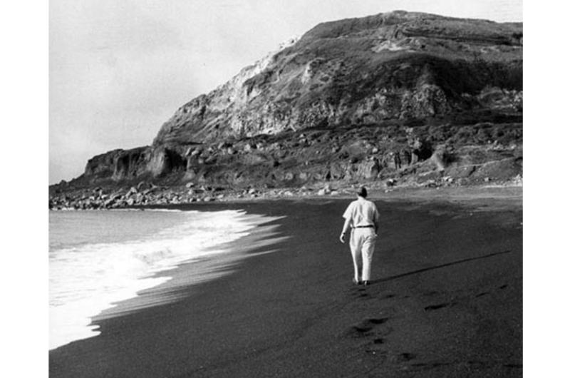 Air Force Capt. John S. Gunnison, who took part in the World War II invasion of Iwo Jima as a Marine 15 years earlier, walks along the beach toward Mt. Suribachi during his first visit to the island since the battle.