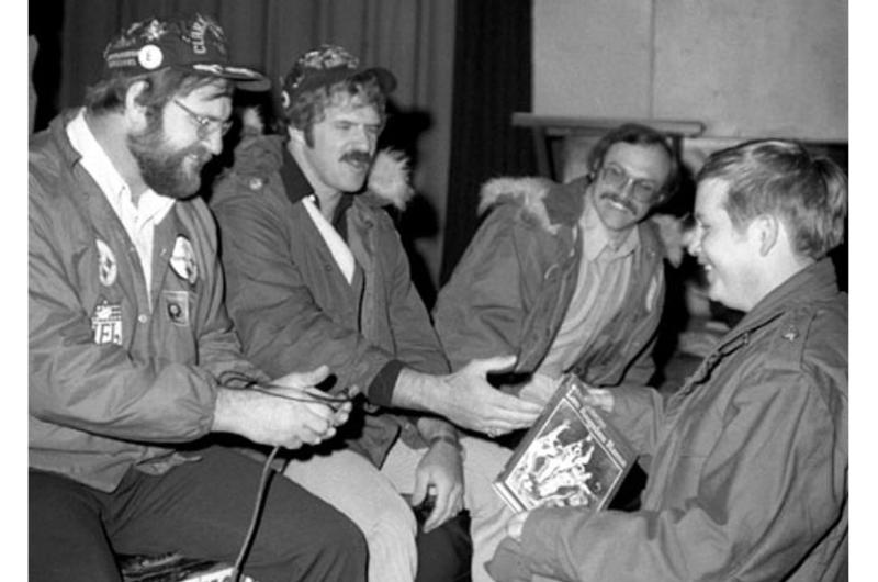 Pfc. Gary Rundell of 1st Battalion, 3rd Infantry is given a football book by Ray Mansfield, Tom Mack and Rocky Bleier during a drawing at Camp Greaves, near the Korean DMZ.