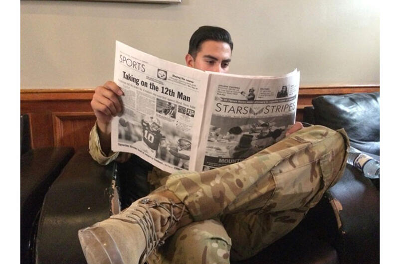 A soldier at Bagram Airfield reads Stars and Stripes