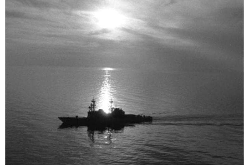 The USS Fife, seen from a helicopter, is silhouetted against a Gulf of Oman sunset in 1990.