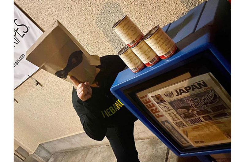 A Beefaroni Bandits member poses with cans of Beefaroni left outside the Stars and Stripes office at Yokota Air Base, Japan, Monday, June 1, 2020.