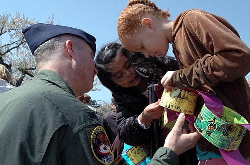 Cummings Elementary School third-graders Kaia Fleming, right, and Danielle Goodyear show Col. Van Wimmer Jr. the links they made to celebrate the DOD's Month of the Military Child during a ceremony Friday at Misawa Air Base, Japan.