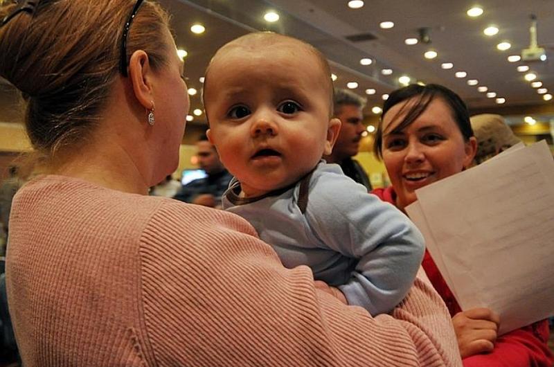 Ronin Barber, six months, waits his turn in a pre-processing line Saturday at Misawa Air Base, Japan, for family members wishing to leave Japan under a 'voluntary departure' program following a devastating earthquake and tsunamis that hit Japan on March 11.