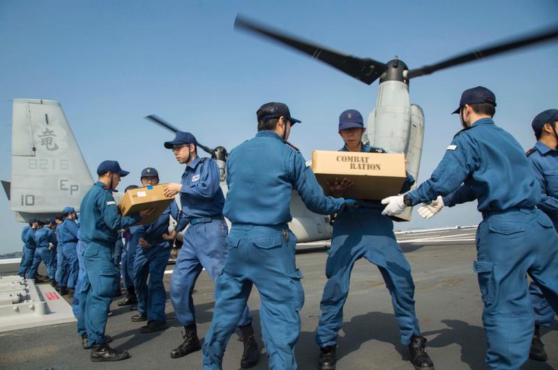 U.S. Marines assigned to the 31st Marine Expeditionary Unit and Japan Self Defense Force members transport supplies onto an MV-22B Osprey aboard the Japanese destoyer JS Hyuga, April 19, 2016.