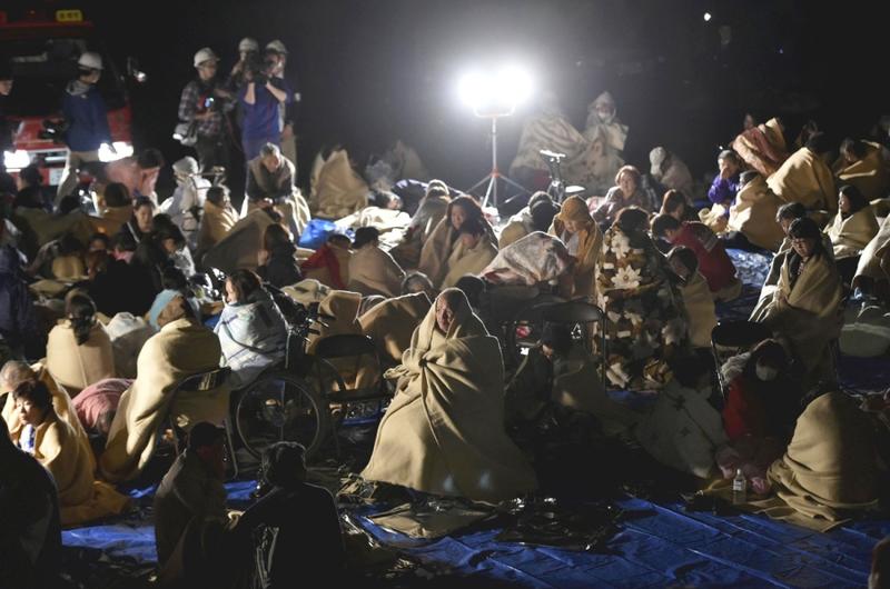 People are seen at a parking lot in Mashiki, Kumamoto Prefecture, Japan, at 1:12 a.m. on Friday after evacuating their homes.