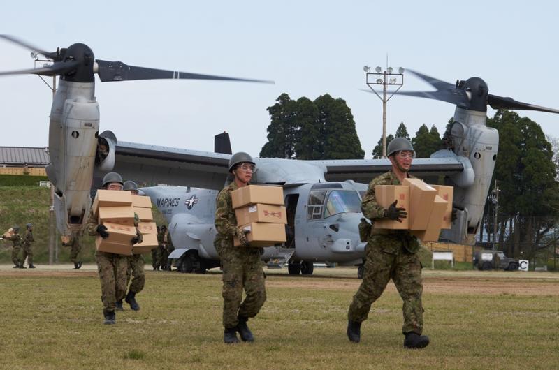 Soldiers from the Japan Ground Self-Defense Force unload emergency aid off a U.S. MV-22 Osprey at Hakusui Sports Park in Kumamoto, Japan, on Wednesday, April 20, 2016.
