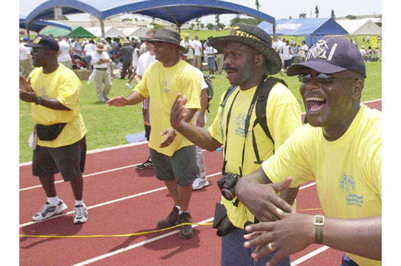 Volunteer encouragers, from right to left, Marine Staff Sgt. Kelvin Roberts, Earl Gittens, Gunnery Sgt. Darryl Dyson and Gunnery Sgt Terrell Lasker cheer on runners in a 100-meter dash.