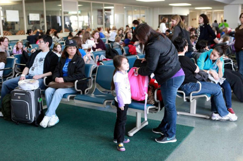 U.S. military family members wait to board a flight from Yokota Air Base, Japan, to Seattle, on Saturday.
