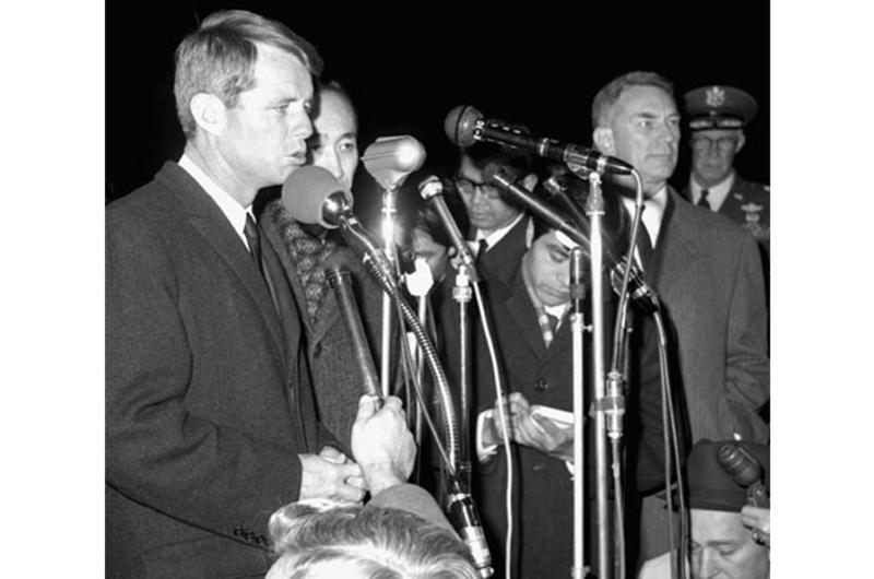 Robert Kennedy speaks to reporters and well-wishers at Yokota. At right is the U.S. Ambassador to Japan, Edwin O. Reischauer.