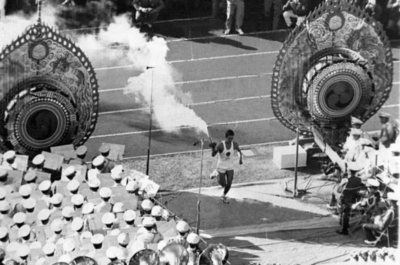Yoshinori Sakai, the Olympic flame torchbearer, runs to light the Olympic cauldron
