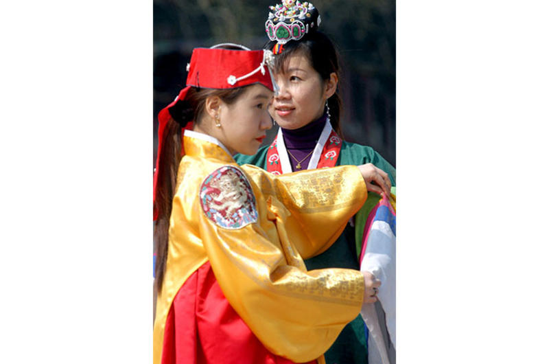 Traditional Korean dresses called hanboks are available on racks near Gyeonghoeru, a structure surrounded by a pond lined with trees, for those who’d like to dress up for a photograph.