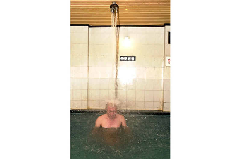 A man relaxes under a jet of water spraying from the ceiling into a pool at the Seolbong Onchon Tourist Hotel.
