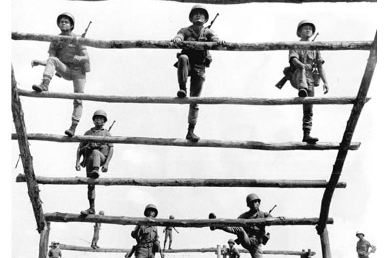 It's up and over the ladder on the rugged 100-yard infiltration course for South Vietnamese army recruits at the 18th ARVN Training Center near Gia Rai, 52 miles northeast of Saigon.