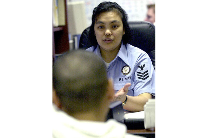 Navy Counselor 1st Class Neilyn Dionisio gives career advice to a young sailor at Yokosuka Naval Base.