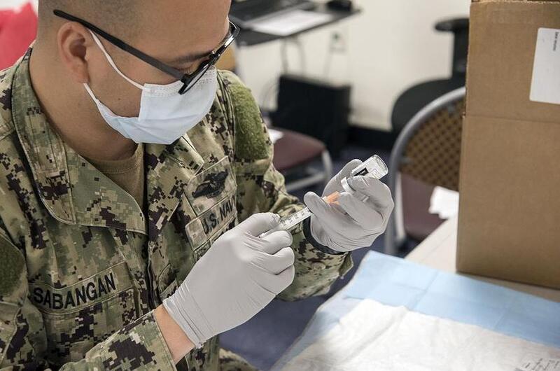A sailor prepares a Moderna COVID-19 vaccine at Naval Air Facility Atsugi, Japan, May 7, 2021.