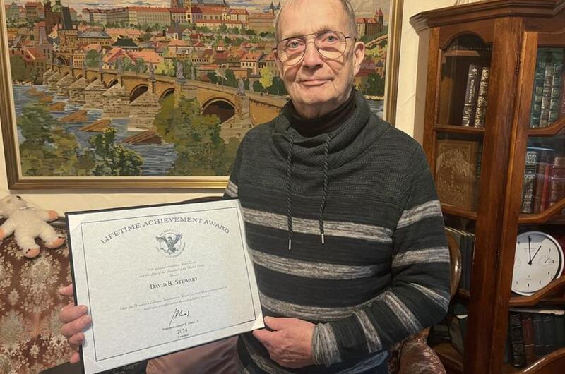 A retired U.S. Army major holds a certificate signed by President Joe Biden.