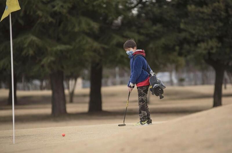 Junior golfer Jake Hughes putts on the Par 3 golf course at Yokota Air Base, Japan.