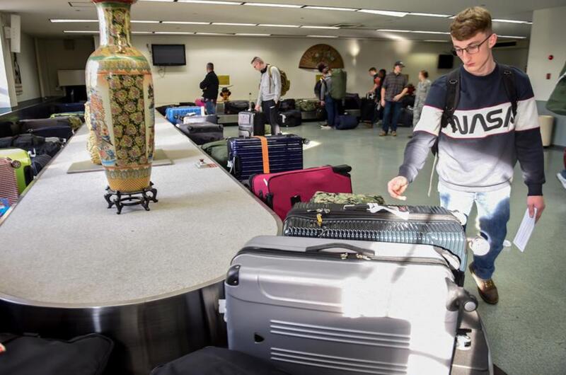 A Patriot Express flyer retrieves his luggage inside the passenger terminal at Yokota Air Base, Japan, Nov. 28, 2018.
