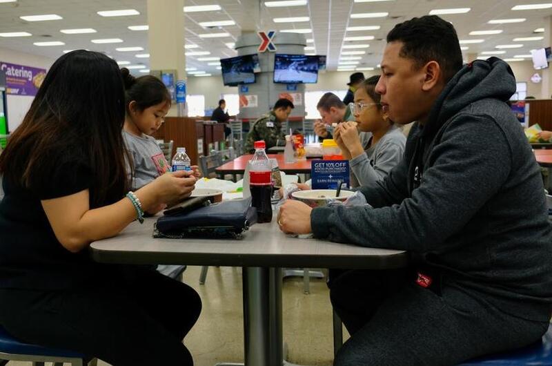 Staff Sgt. Vincent Lim of the 731st Air Mobility Squadron and his wife, Joy Mae Lim, eat with their children at the food court on Osan Air Base, South Korea, Monday, March 2, 2020.