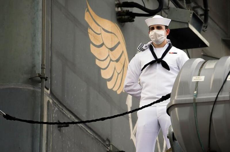 A sailor mans the rails aboard the USS Theodore Roosevelt as the aircraft carrier prepares to depart Naval Base Guam, June 4, 2020.