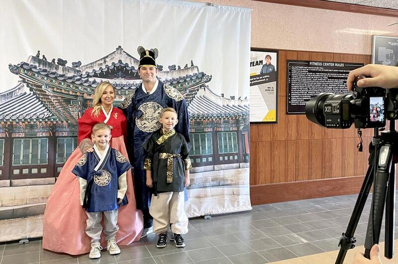 A U.S. soldier and his family pose for a photo while wearing traditional Korean clothing.