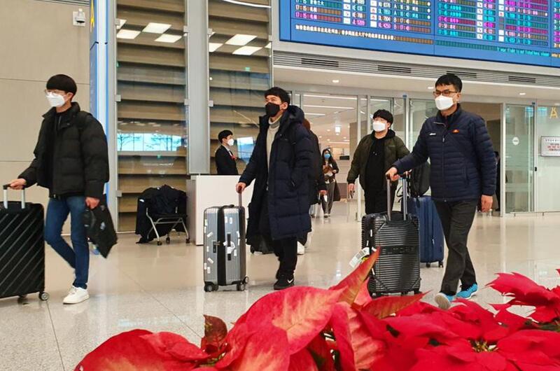 Airplane passengers exit an arrival gate wearing masks at Incheon International Airport, South Korea, Monday, Feb. 3, 2020.