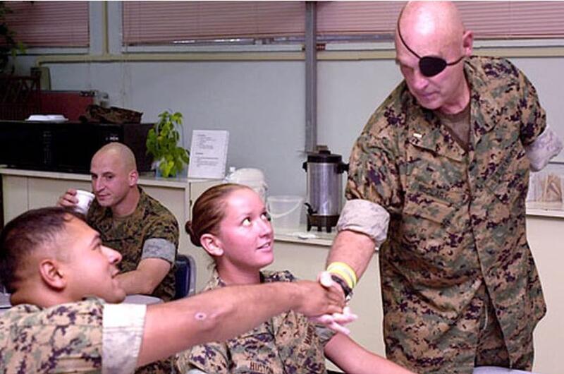 Clebe McClary, a Marine veteran who was severely wounded during the Vietnam War, shakes hands with Marines at the USO on Camp Hansen, Okinawa, on Friday.