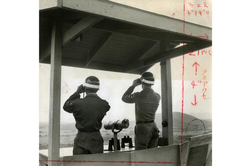 Two unidentified soldiers check for communist movements across the DMZ in North Korea at Outpost Maizie.