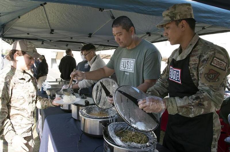 USO volunteers serves single service members a free Thanksgiving meal at Yokota Air Base, Japan, Tuesday, Nov. 22, 2022.