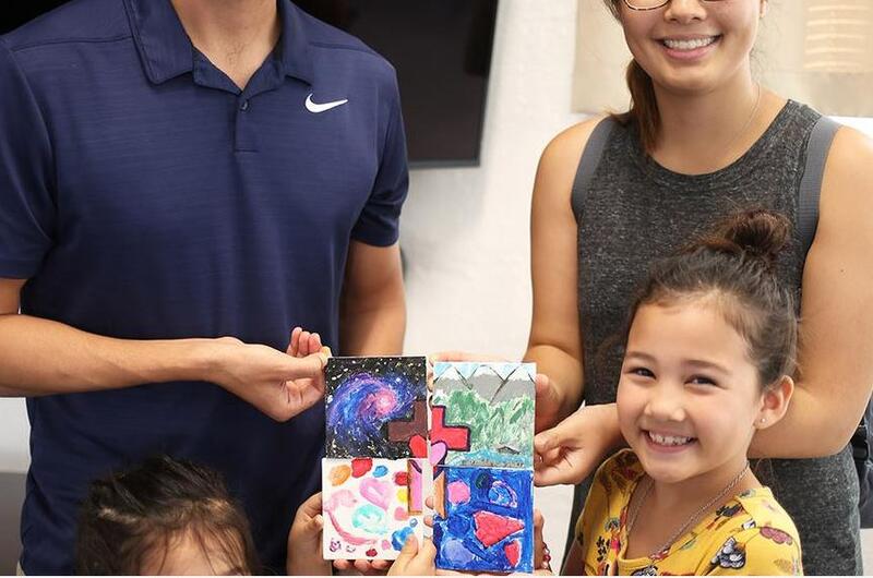 Marine Maj. Sam Wuornos, his wife, Christine, and daughters Evie, 7, and Ella, 4, show off a project they completed from a USO Family Activity Box at Camp Foster, Okinawa, Wednesday, Aug. 28, 2019.