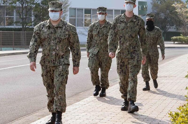 Sailors assigned to Sasebo Naval Base, Japan, wear face masks and practice social distancing while walking on base April 9, 2020.