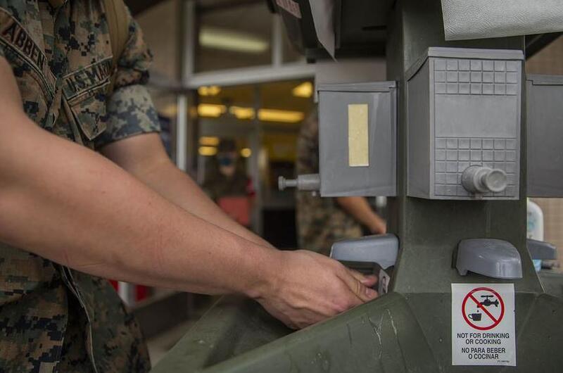 Lance Cpl. Abben Nicholas, of the III Marine Expeditionary Force Support Battalion, uses a hand-washing station earlier this year at Camp Hansen, Okinawa. 