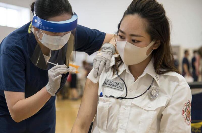Fire inspector Kaede Miura receives her first dose of the Moderna COVID-19 vaccine at Yokosuka Naval Base, Japan, Friday, June 18, 2021.