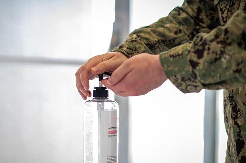 A sailor sanitizes his hands before entering the Navy Exchange at Yokosuka Naval Base, Japan, Aug. 13, 2020. 