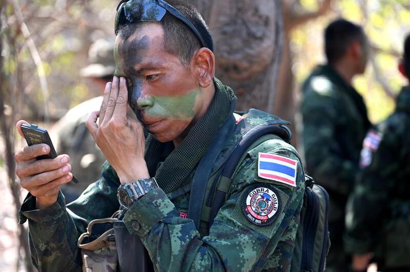 A Thai soldier applies face paint.