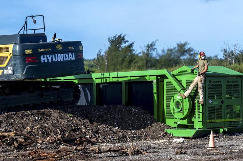 An airman works with an incinerator.