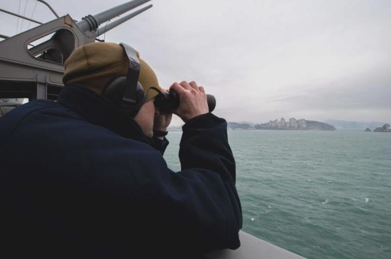 Petty Officer 2nd Class Thomas Gammon, of Georgetown, Texas, stands lookout aboard the aircraft carrier USS Carl Vinson as it pulls into Busan, South Korea, for a scheduled port visit, March 2, 2025.