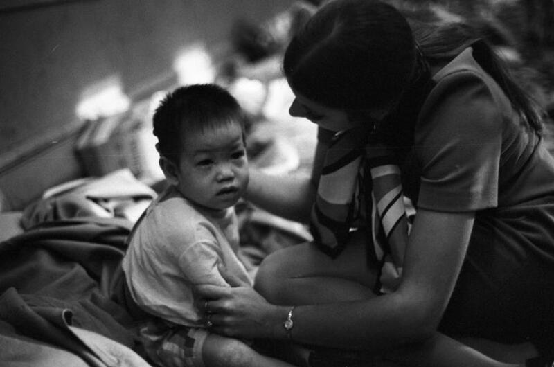 A young child is held by a woman.