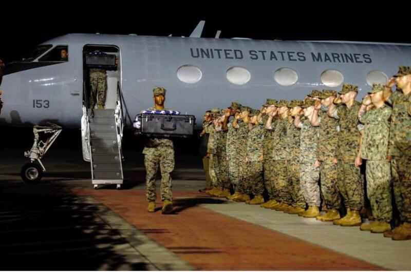 Marines saluting as remains are transported.