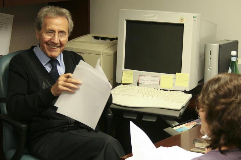 A man smiles at a woman in an office.