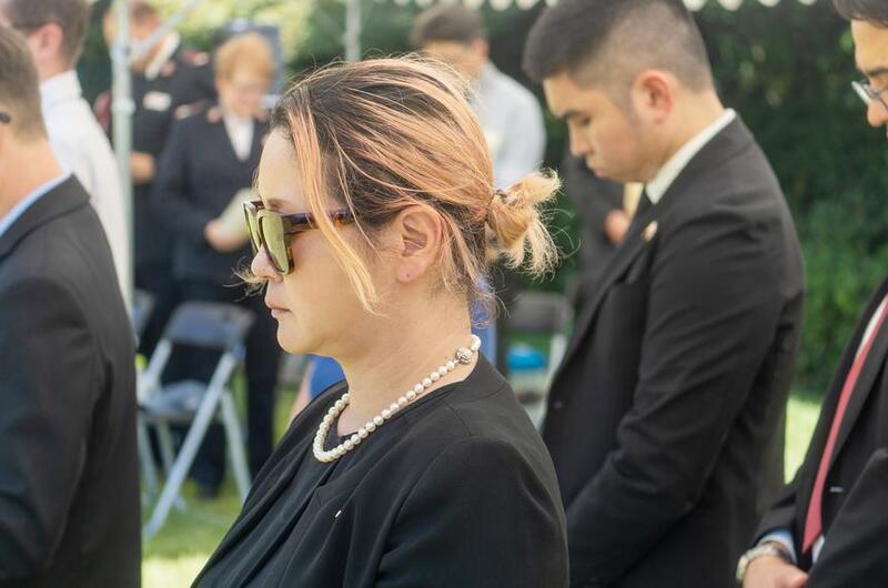 People dressed in black bow their heads during a memorial service.