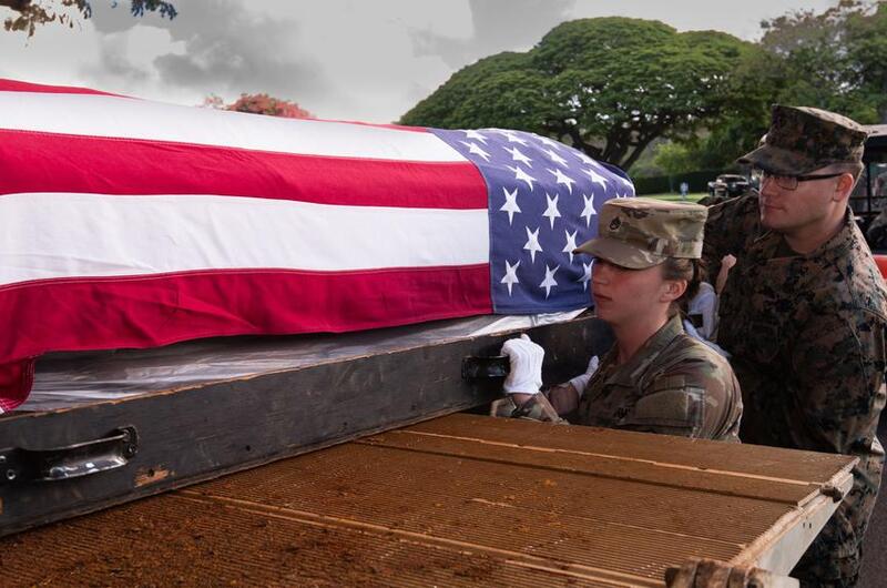 A transfer case containing Korean War remains is loaded into a truck.