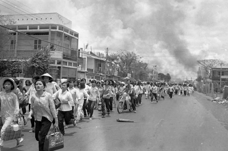 Refugees flee burning buildings near Tan Son Nhut. Viet Cong and North Vietnamese forces started shelling more than 120 provincial capitals, towns and allied military installations across South Vietnam and battled governement and U.S. troops inside the capital Saigon, May 5th.