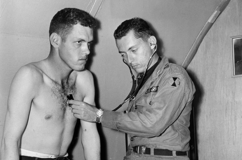 Chest checkup is given to PFC Rollie E. Fansler of the 4th Missile Command by Capt. Alan J. Serrins, medical officer of the 17th Inf. aid station. Although small, the station is one of the best-equipped military medical facilities in Korea.