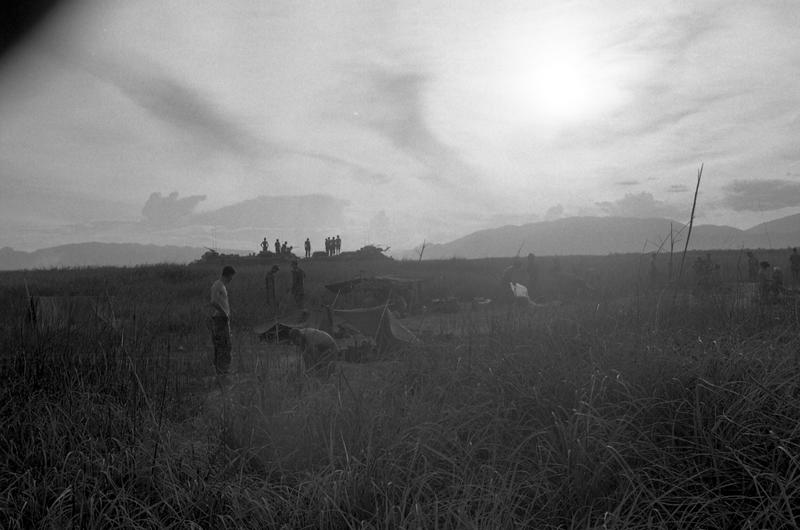 Marines prepare to go out on a sweep as the early morning sun tries to break through the clouds, having just risen above the mountains.