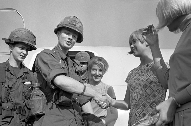 Fresh troops disembark from their airplane at an unindentified airport in Vietnam and are bid farewell by the pretty flight attendants of Braniff International airways on whose airplane they flew. They are members of the 6th Battalion, 31st Infantry, 9th Infantry Division.