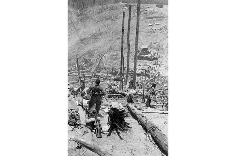 An unidentified African American soldier looks out over the desolate and torn-up landscape of Hill 937 of Dong Ap Bia, better known to Americans as Hamburger Hill.